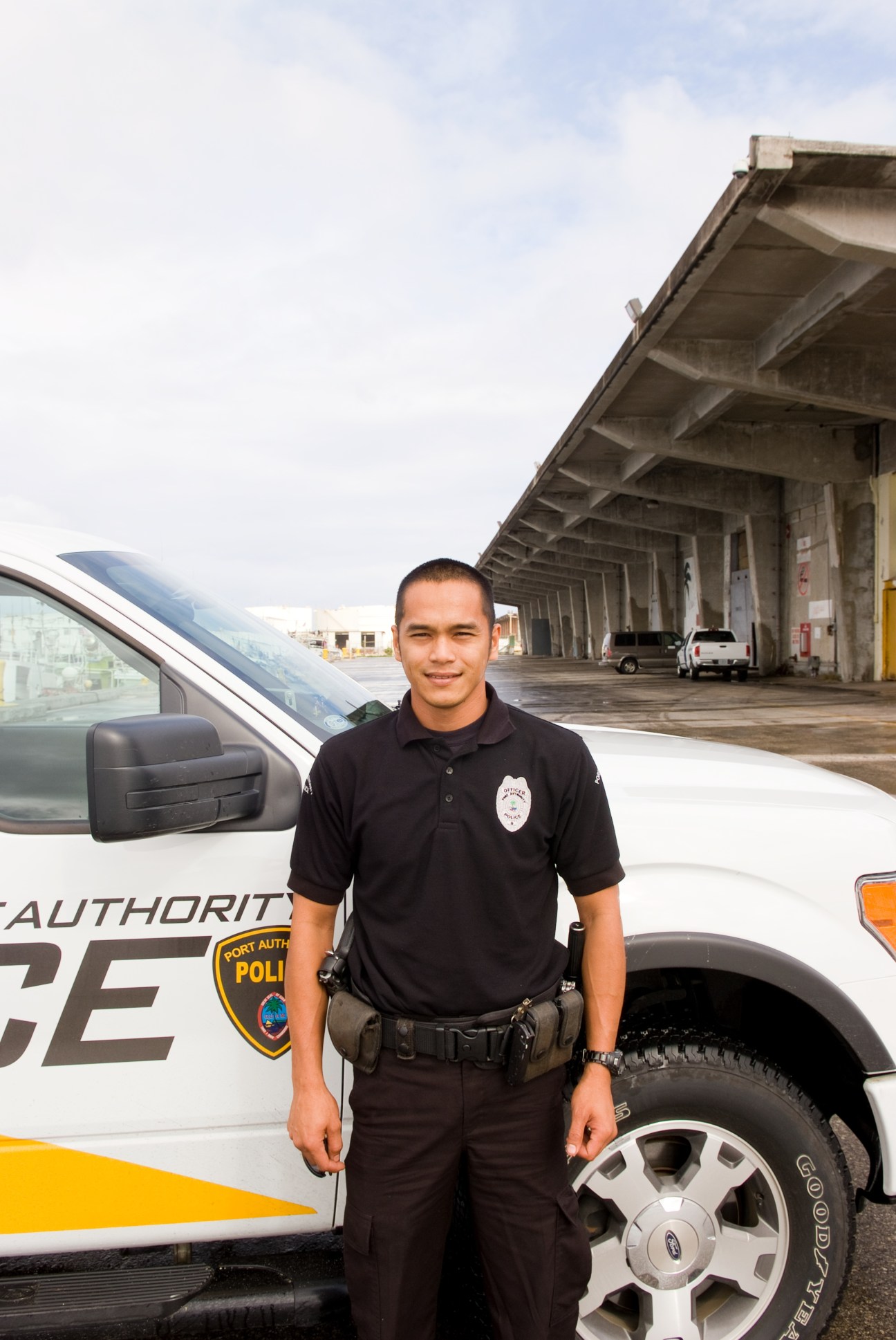 Port Authority police officer Jonathan Aguon stands beside a patrol vehicle at Guam's airport.