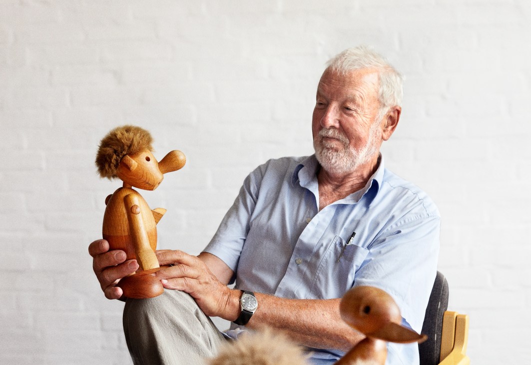 Hans Bølling holds a wooden bird prototype design in his hands.