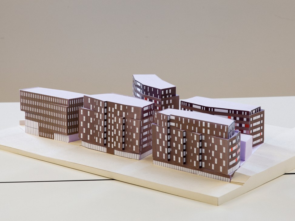 Architectural model of Low2No Helsinki project showing brown brick buildings with white roofs on a base platform.