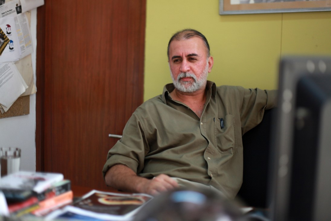 Tarun Tejpal, editor-in-chief of Tehelka magazine, sitting at his desk in a yellow-walled New Delhi office.