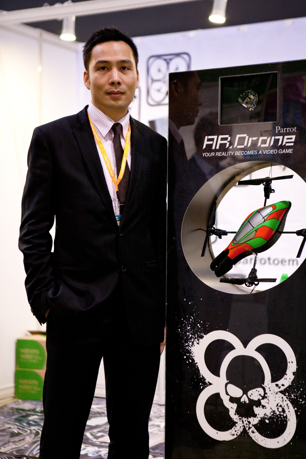 Ronald Cheung from Parrot stands beside the AR Drone quadricopter display at the toy fair.