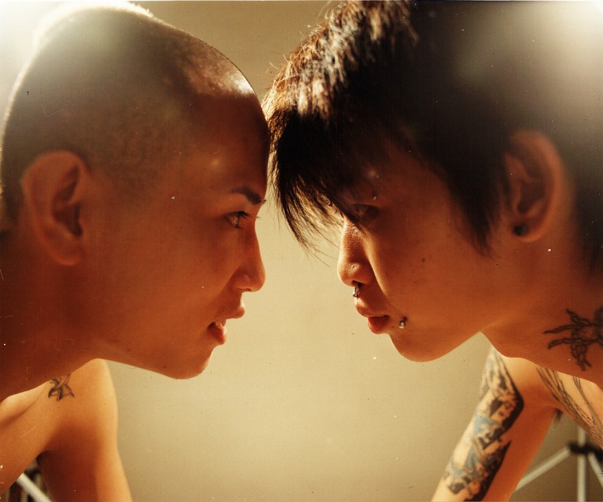 Two shaved-headed teenagers with tattoos face each other in profile from Royston Tan's film '15'.