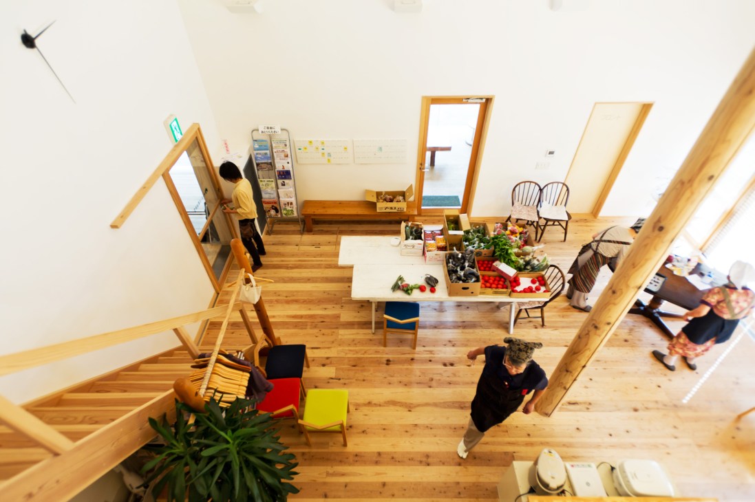 Overhead view of Yuimarl Nasu community space with wooden floors, natural materials, and residents engaged in activities.
