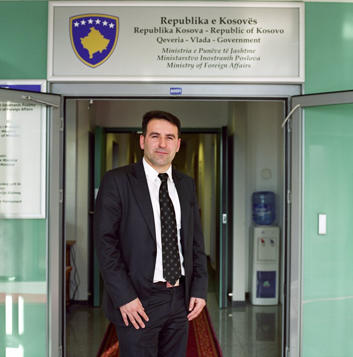 Man in dark suit standing in doorway of Kosovo Ministry of Foreign Affairs office.