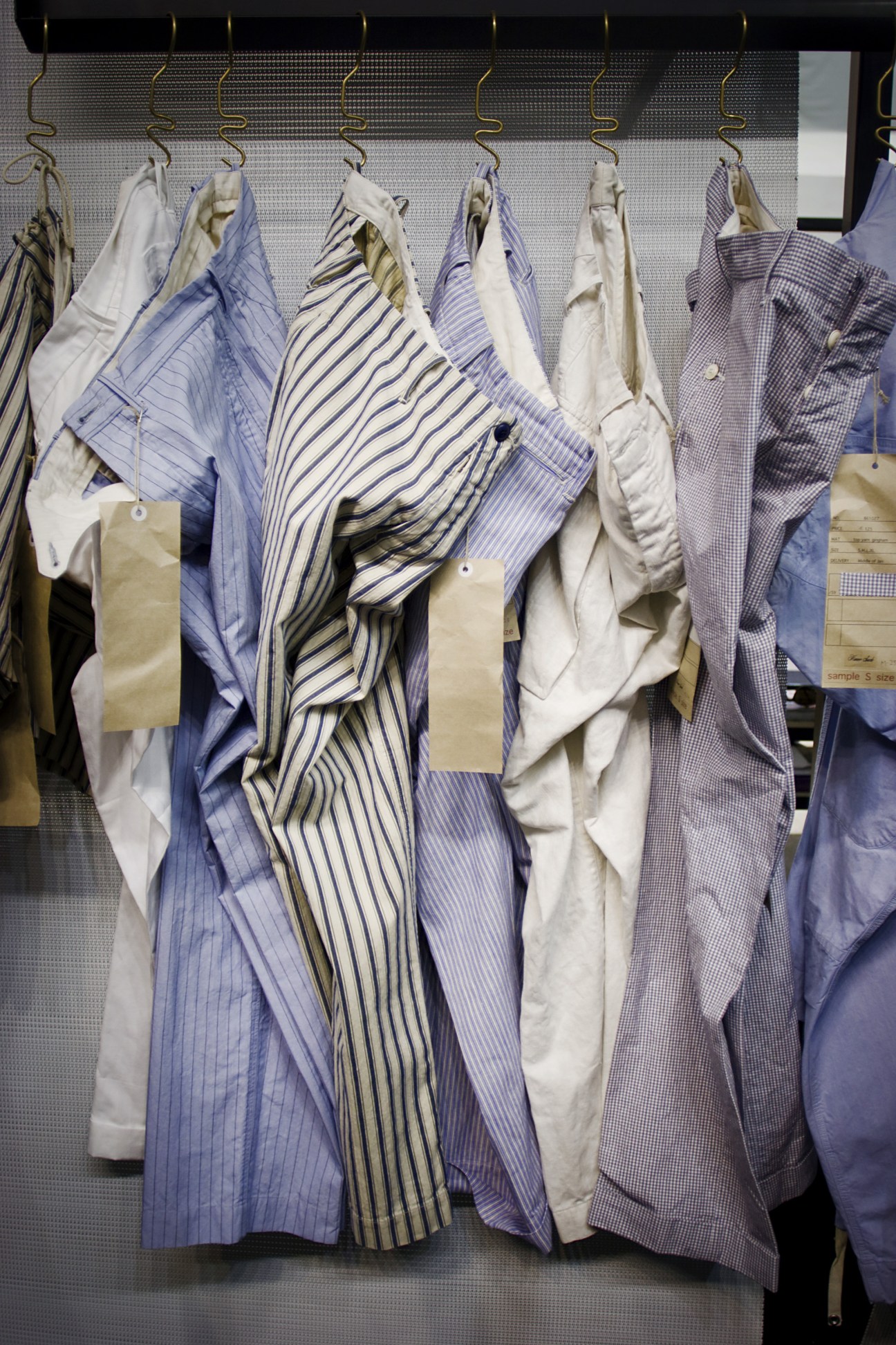 Haversack trousers in various patterns displayed on hangers at a fashion trade show.