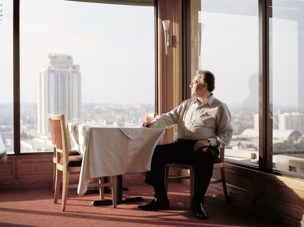 Nauman Wannes, manager of Mirage hotel, sitting at a table with a cityscape view behind him.