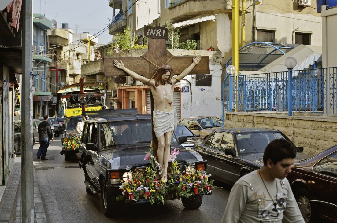 A Maronite Catholic Easter procession with a crucifix statue decorated with flowers on a street in Ashrafieh.