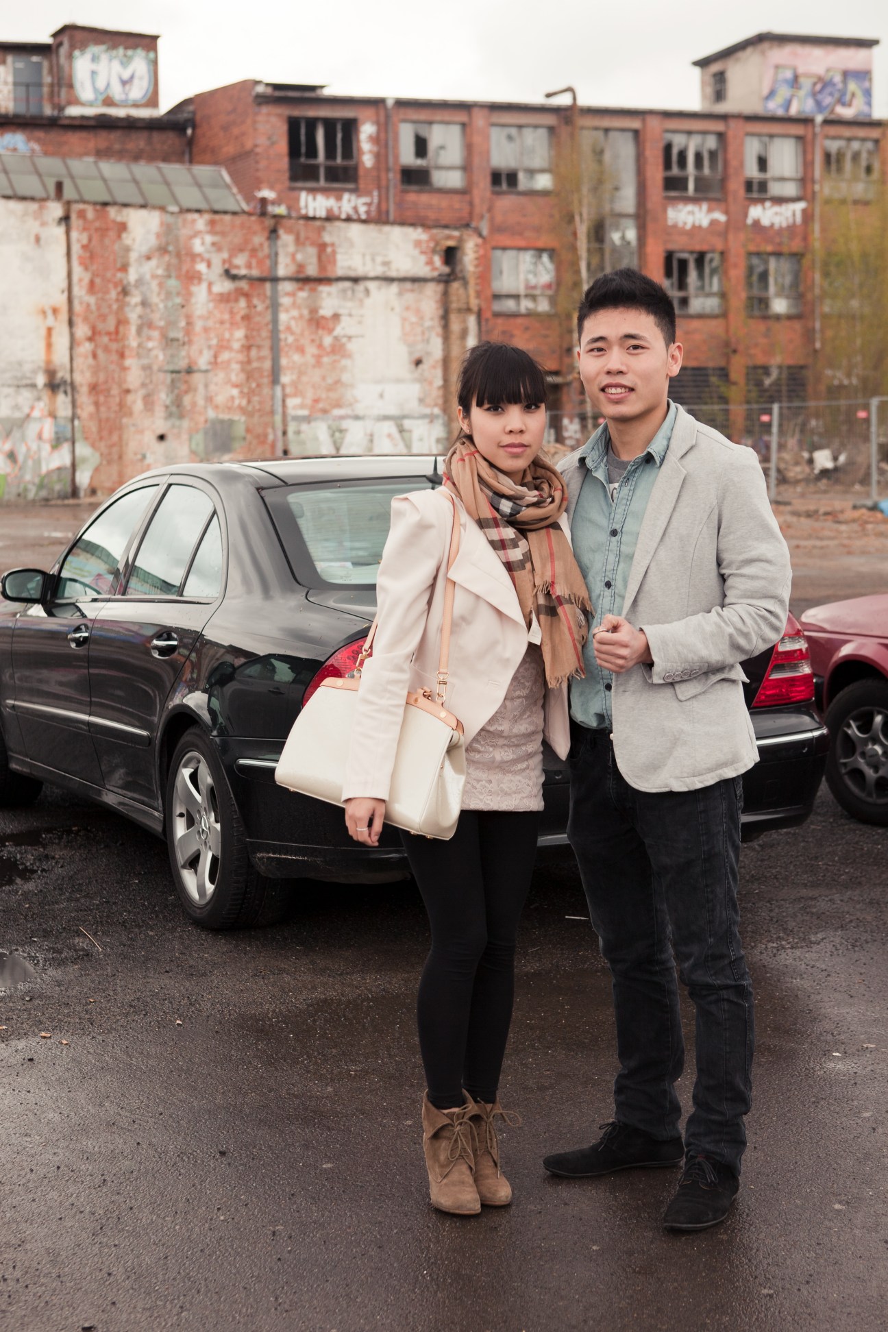 Two young Vietnamese people stand together in front of industrial buildings in Berlin.