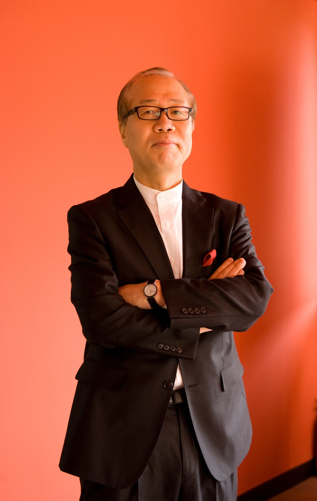 Kun-pyo Lee, head of industrial design at KAIST, standing with arms crossed against an orange background.