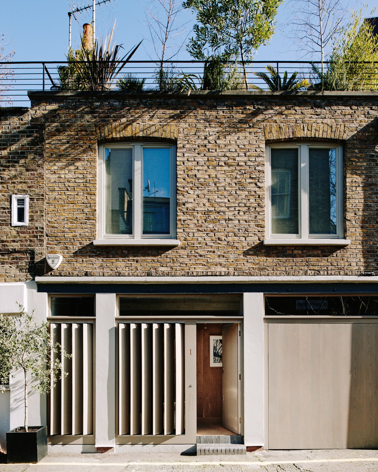 Bloomsbury mews facade with manually controlled vertical oak fins that open to allow light while maintaining privacy.