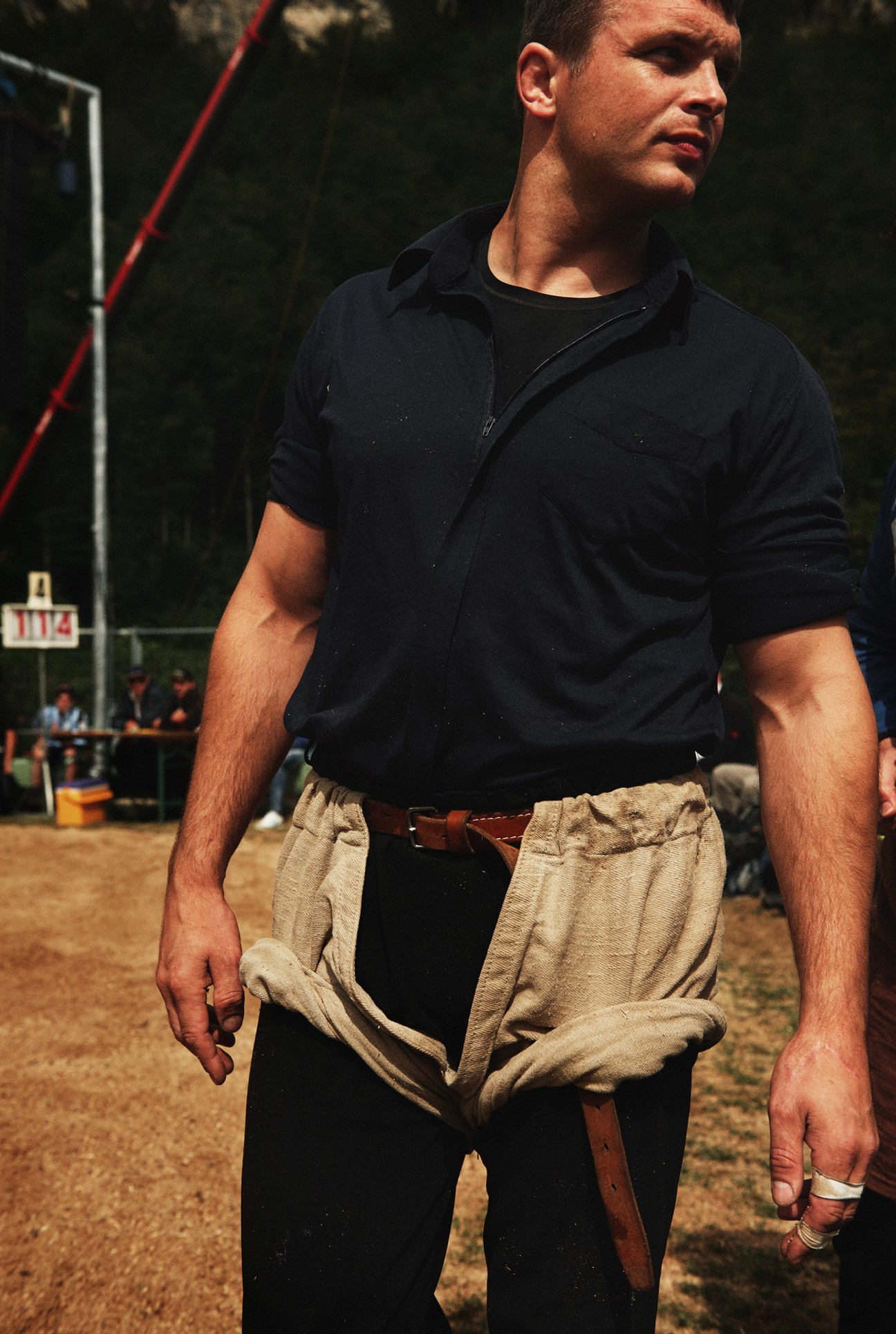 Swiss wrestler wearing traditional burlap schwinghosen shorts and leather belt at Brünig wrestling event.