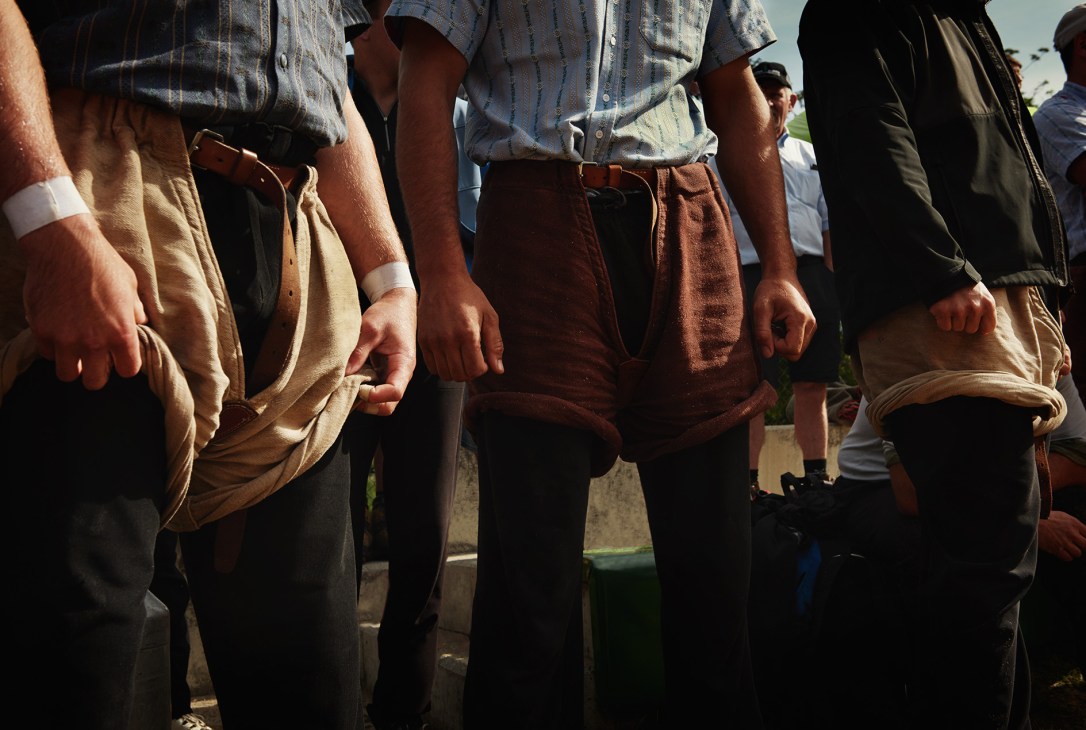 Swiss wrestlers in traditional schwinghosen burlap shorts and white shirts preparing for a Schwingen match.