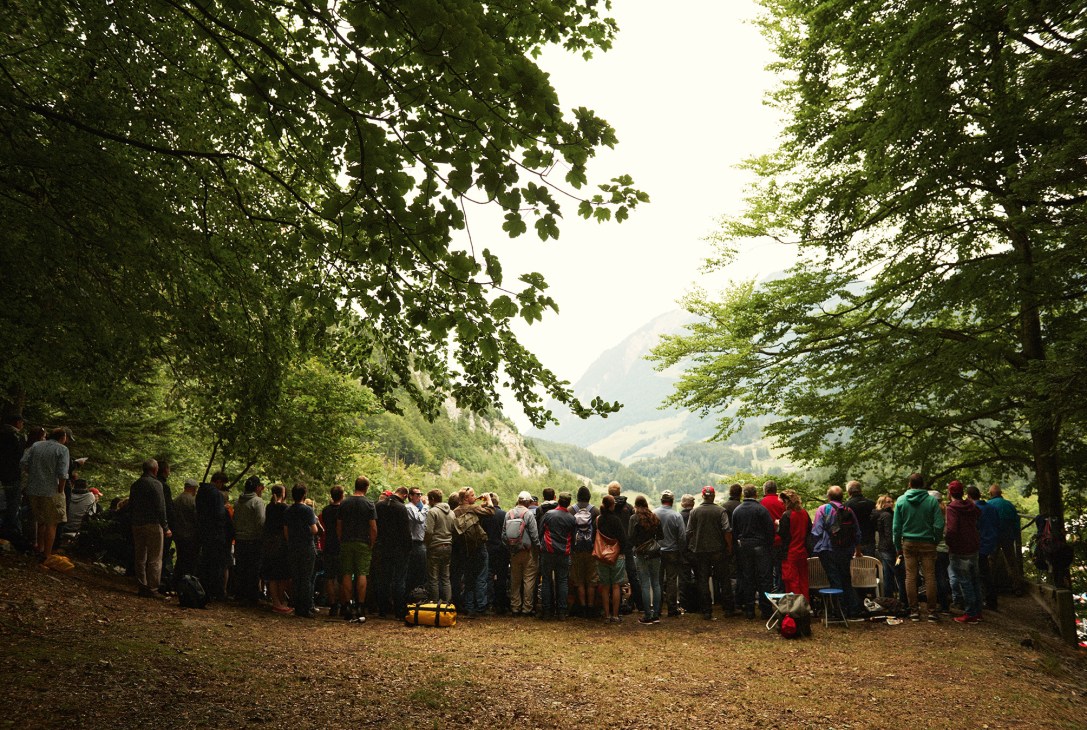 Spectators gather on a forested hillside overlooking a Alpine valley during the Schwingen wrestling event.