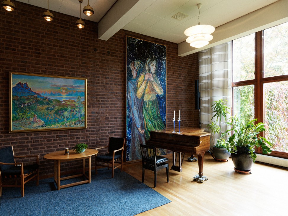 Music room with custom-made Steinway piano, brick walls, modernist furniture, and artwork displayed in a mid-century interior space.