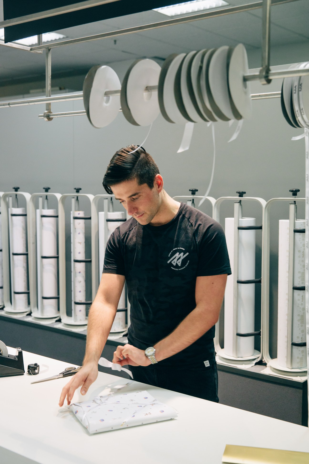 Employee Patrik Niesel wraps a gift at a counter in Kadewe's gift-wrapping department.
