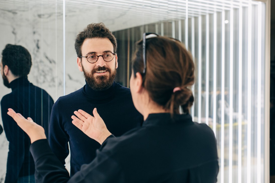 OMA's Ippolito Pestellini Laparelli and designer India Mahdavi conversing in a modern interior space.