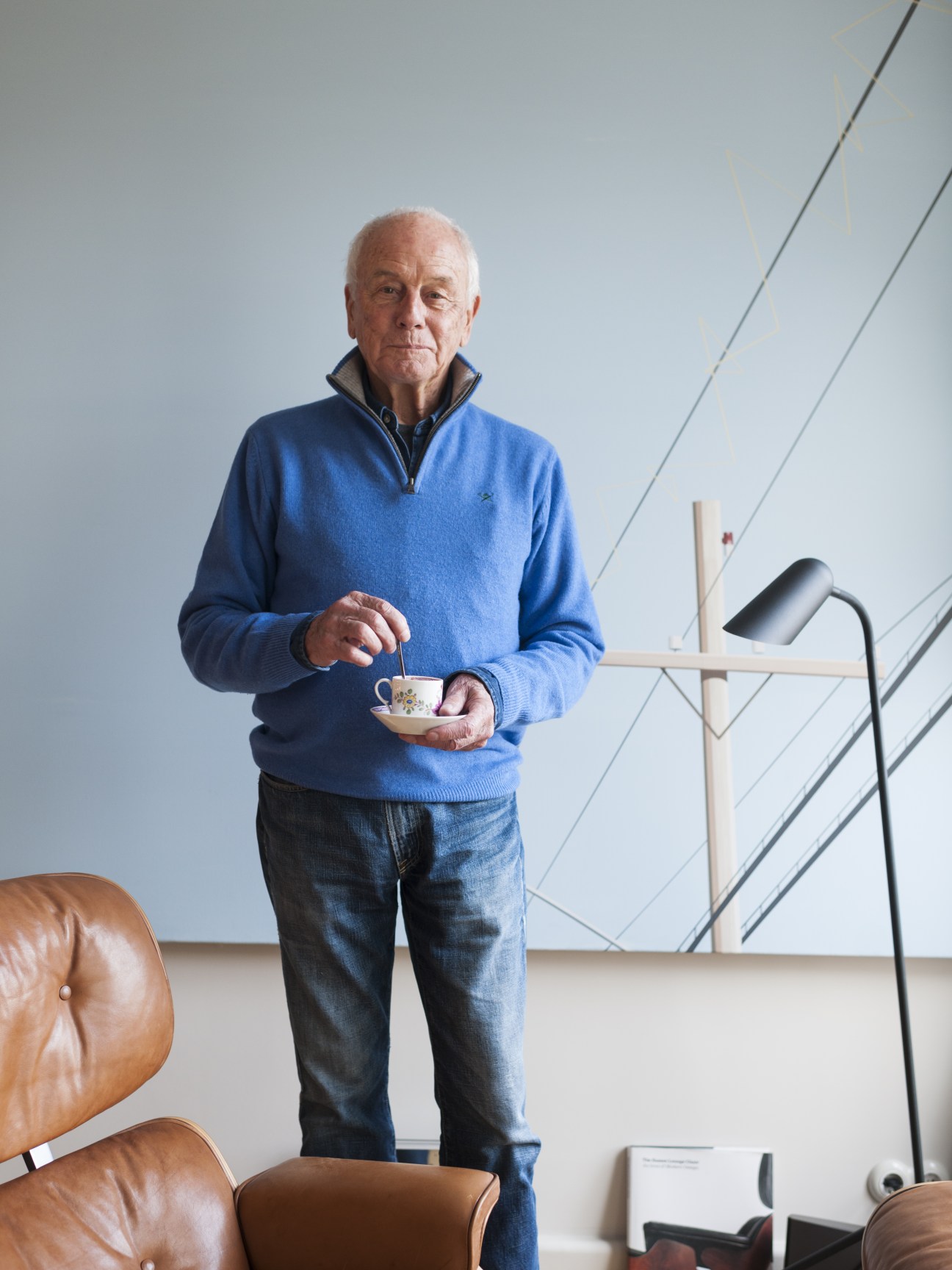 Helmut Trinks stands holding a teacup in his Henselmann Tower apartment.