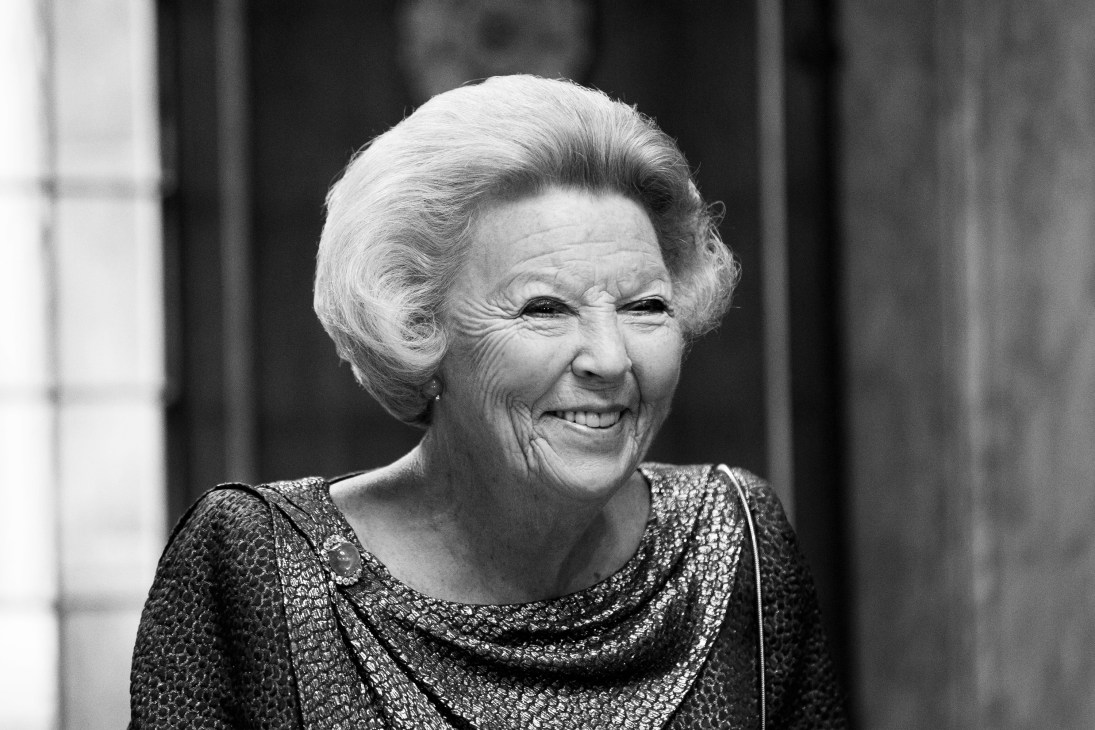 Black and white portrait of Queen Beatrix smiling, wearing a sparkly top.