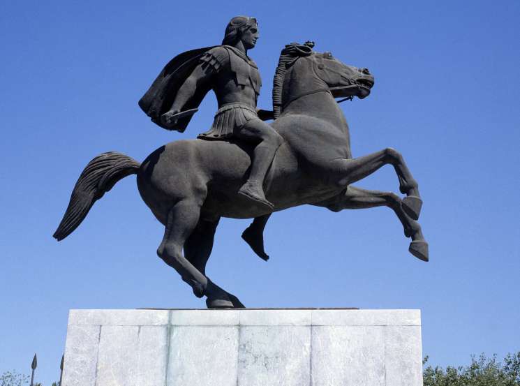 Equestrian statue of Alexander the Great on horseback against a clear blue sky in Thessaloniki.