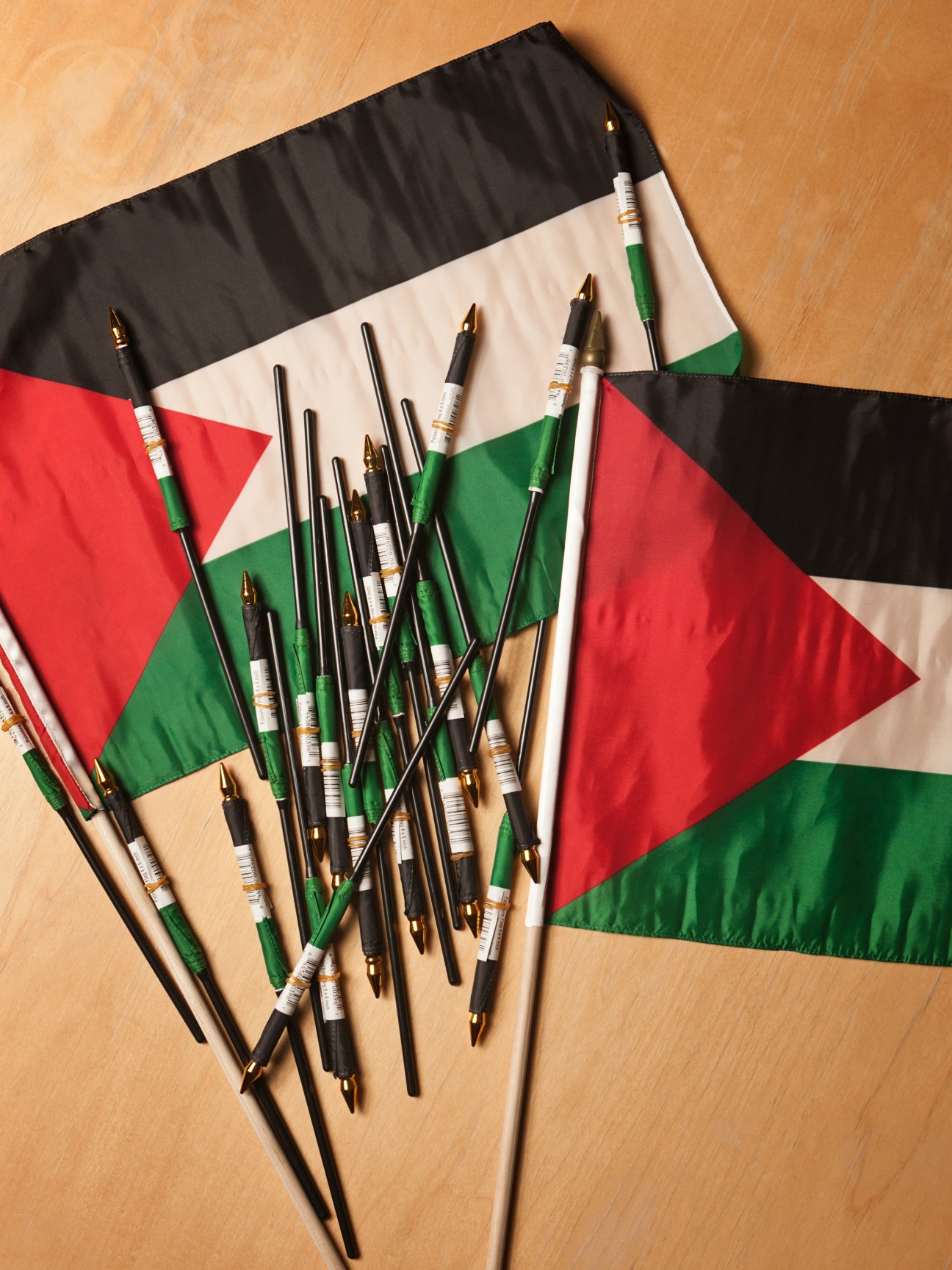 Palestinian flags with pencils arranged on a wooden surface.