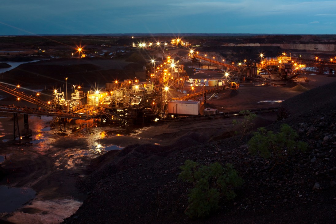 Illuminated manganese processing plant at night with conveyor systems and industrial equipment at Consolidated Minerals in Western Australia.