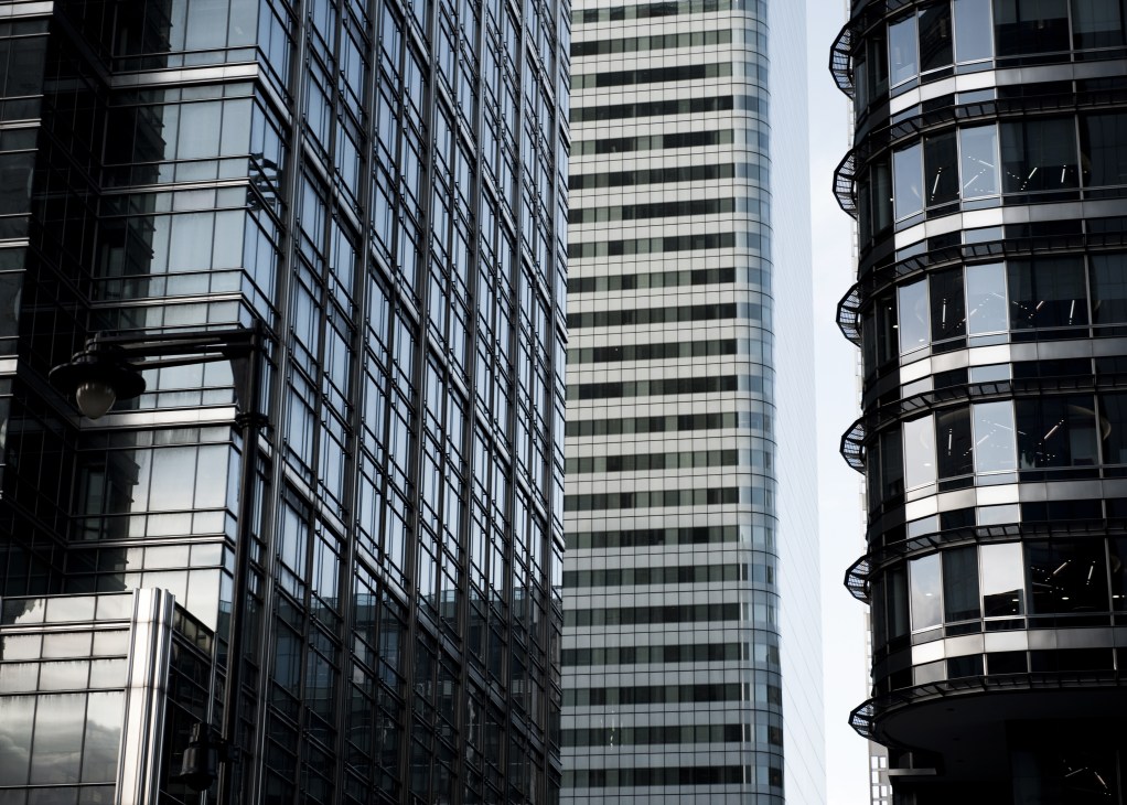 Modern glass and steel office towers with distinctive curved architectural features at Canary Wharf.