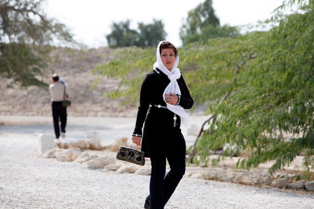 Woman in black outfit and white headscarf walking through Harireh ruins on Kish island