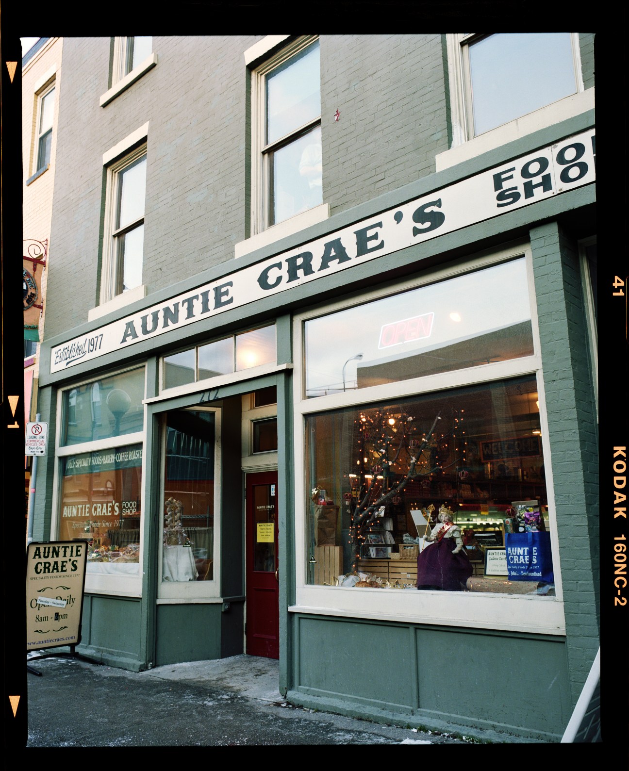 Storefront of Auntie Crae's gourmet shop with green painted brick facade and display windows in St John's.