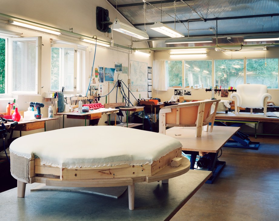 Upholstery workshop at Sjögren factory with fabric-covered furniture frames in progress.