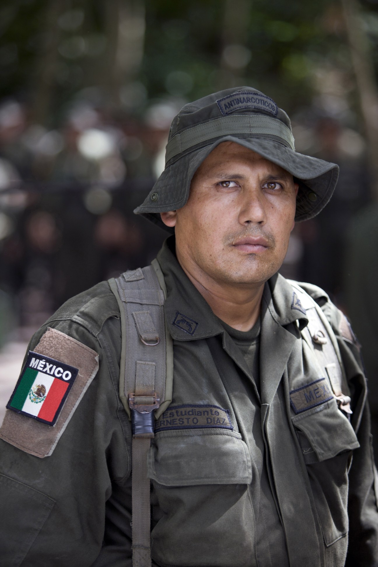 Ernesto Diaz, a Mexican policeman wearing military fatigues with a Mexico flag patch and anti-narcotics headband.