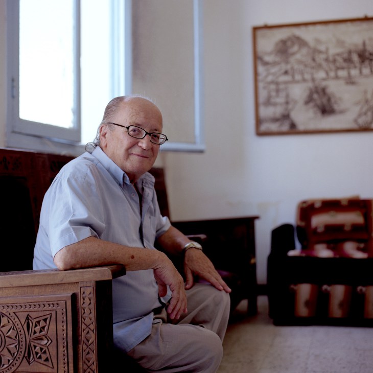 Belkacem Babaci, president of the Casbah Foundation, sitting in an ornately carved chair in a light-filled room.