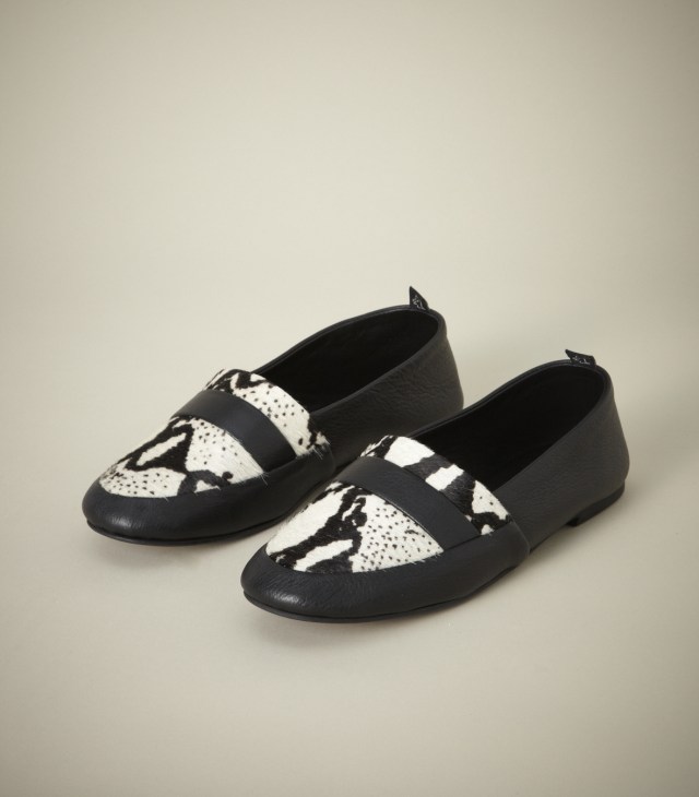 Pair of black and white Newbark loafers with geometric patterned uppers on neutral background.