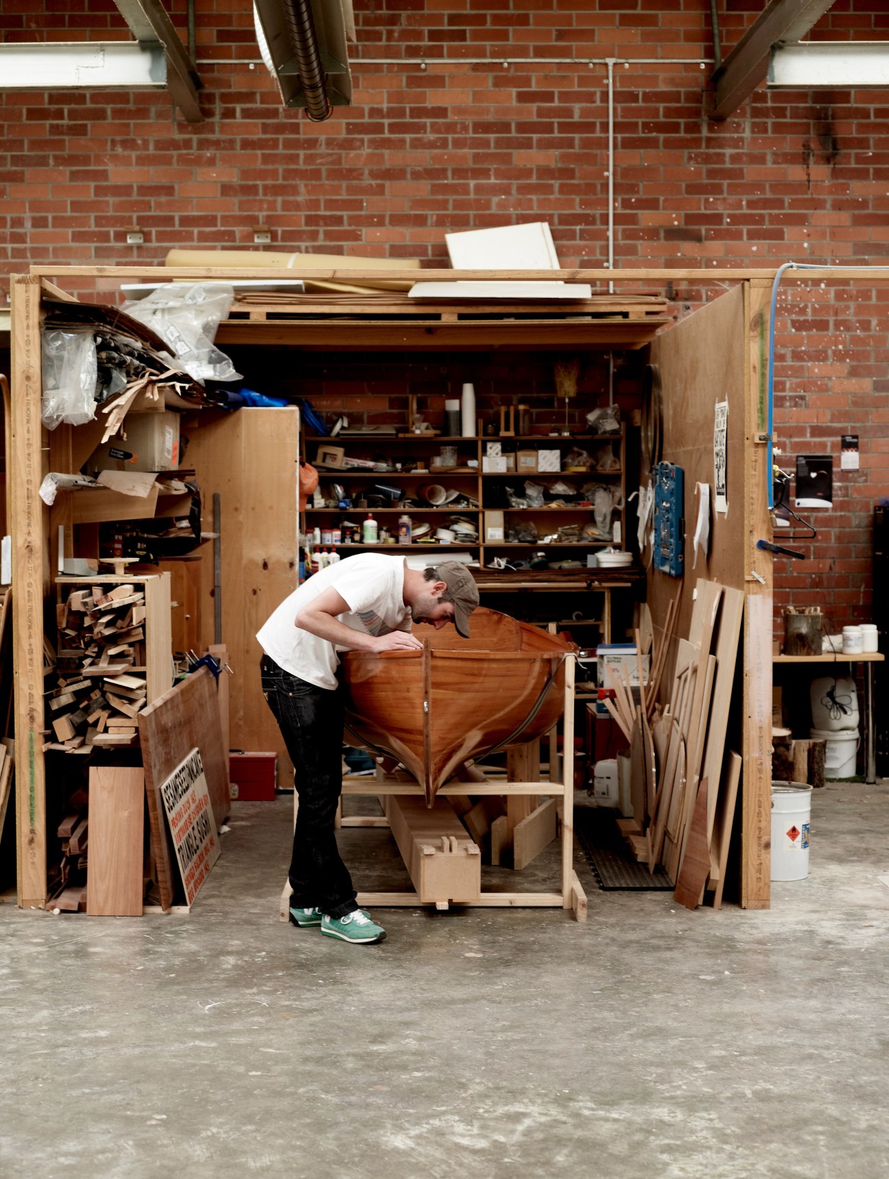 Nick Randall working on a wooden boat hull in his workshop studio.