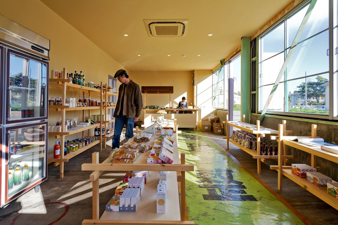 Interior of Newland shop in Kumagaya with wooden shelving, products on display, and bright windows overlooking green landscape.