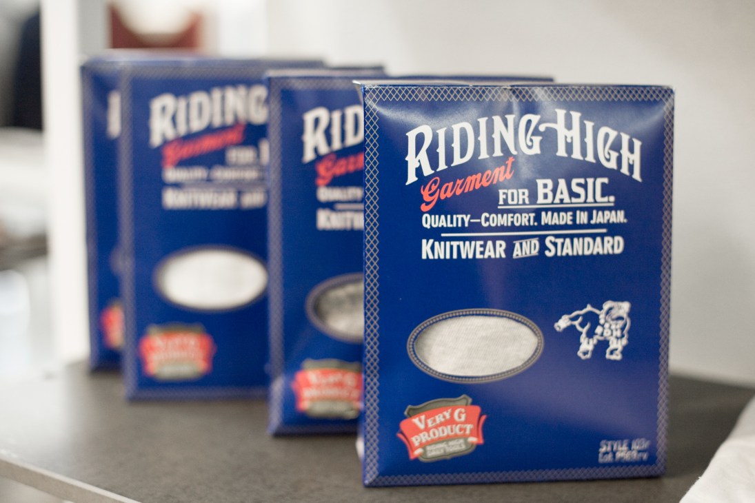 Riding High Garment packaging boxes in blue with white and red text, made in Japan.