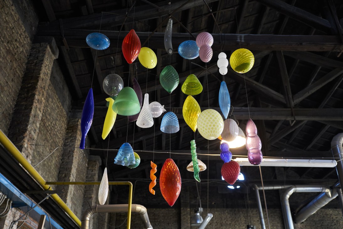 Colorful glass pendants hanging from strings in Gambaro & Tagliapietra's workshop.