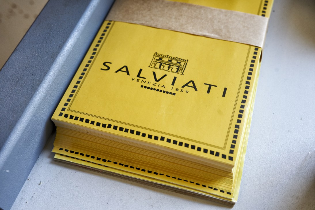 Stack of yellow Salviati Venezia 1859 branded catalogs or sample books with decorative black borders.