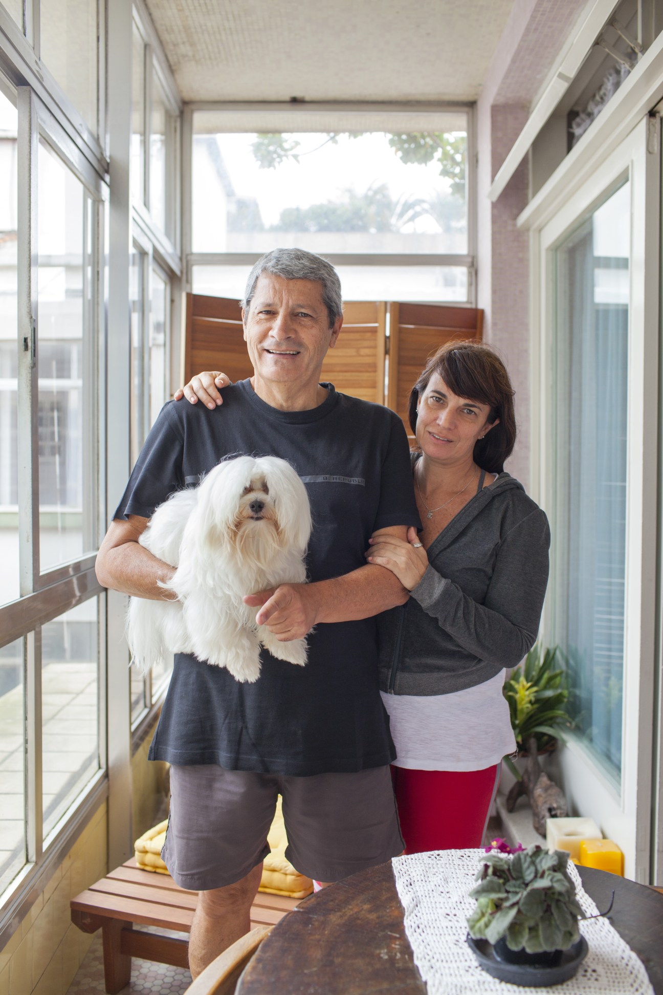Eduardo Caldeira and Monica Mathias with their white Maltese dog Benjamin Star in their apartment.