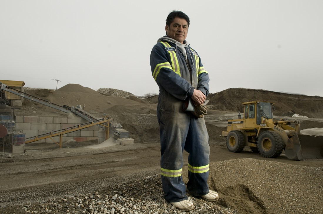Worker Louis Baptiste stands in safety gear at Oliver Readi-Mix gravel pit in British Columbia, an Osoyoos Indian Band project.