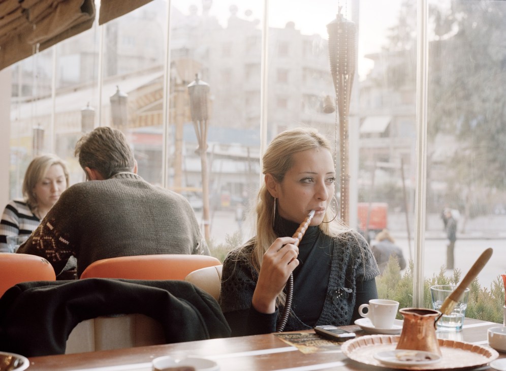 Woman smoking hookah at Monroe café with city view in Al-Aziziah neighbourhood