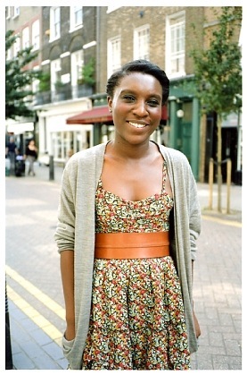 Florence Laud-Anderson, a resident of Lamb's Conduit Street, smiling on the street with Victorian buildings behind her.