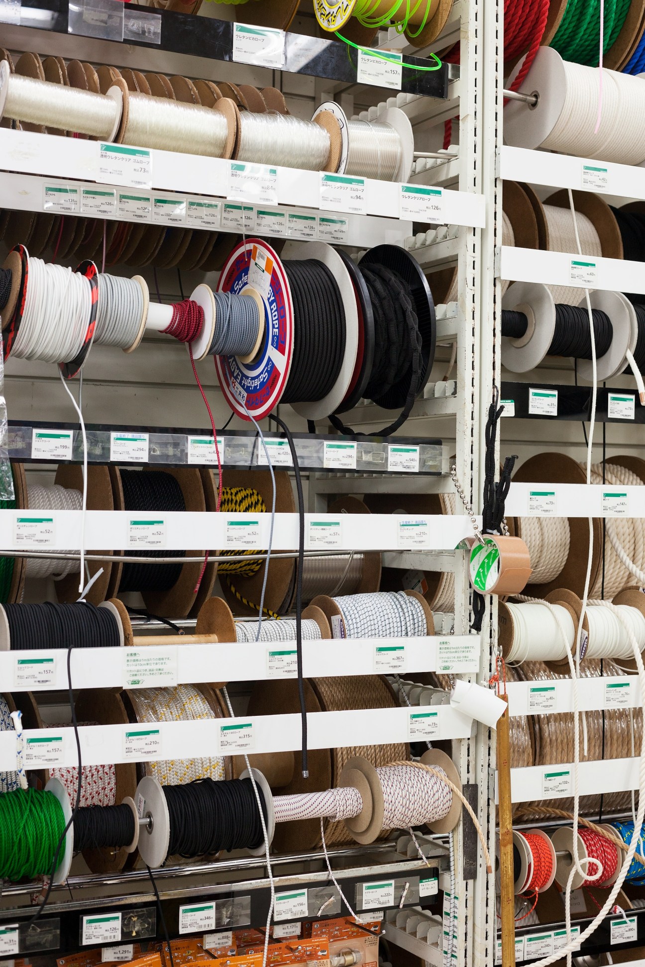 Shelves display colorful electrical cords and cables on spools in various colors and sizes.