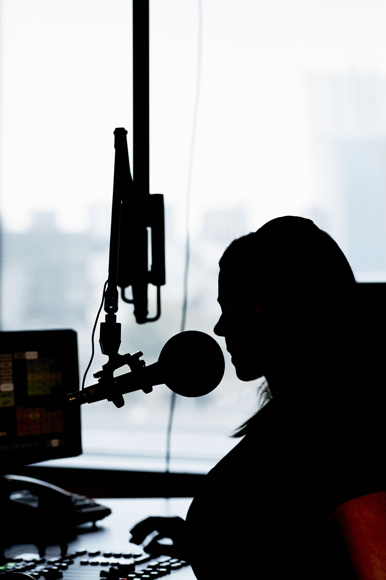 Silhouette of radio presenter Myf Warhurst at microphone in Double J studio.