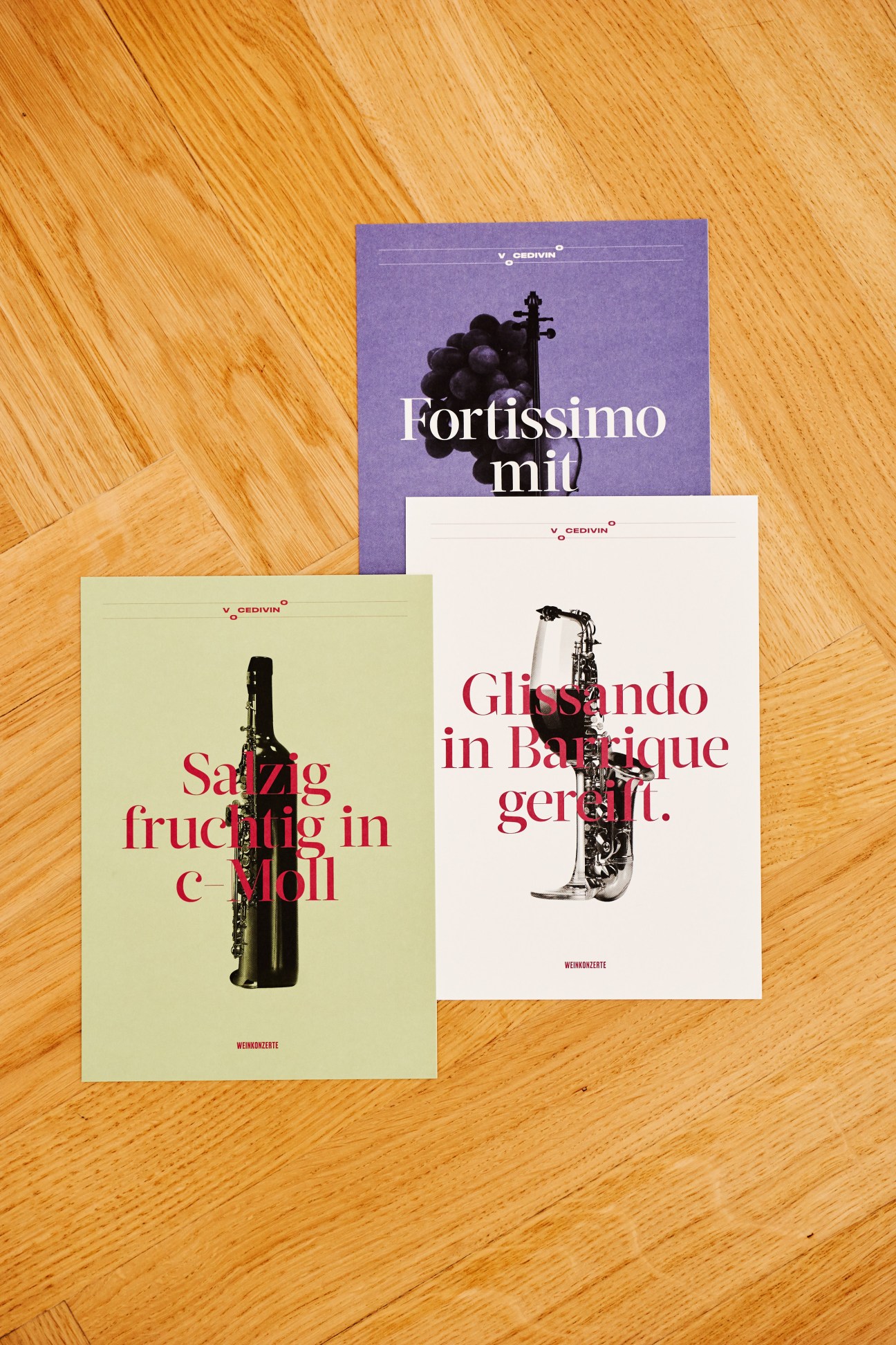 Three printed brochures with Italian text and musical instruments displayed on wooden surface.