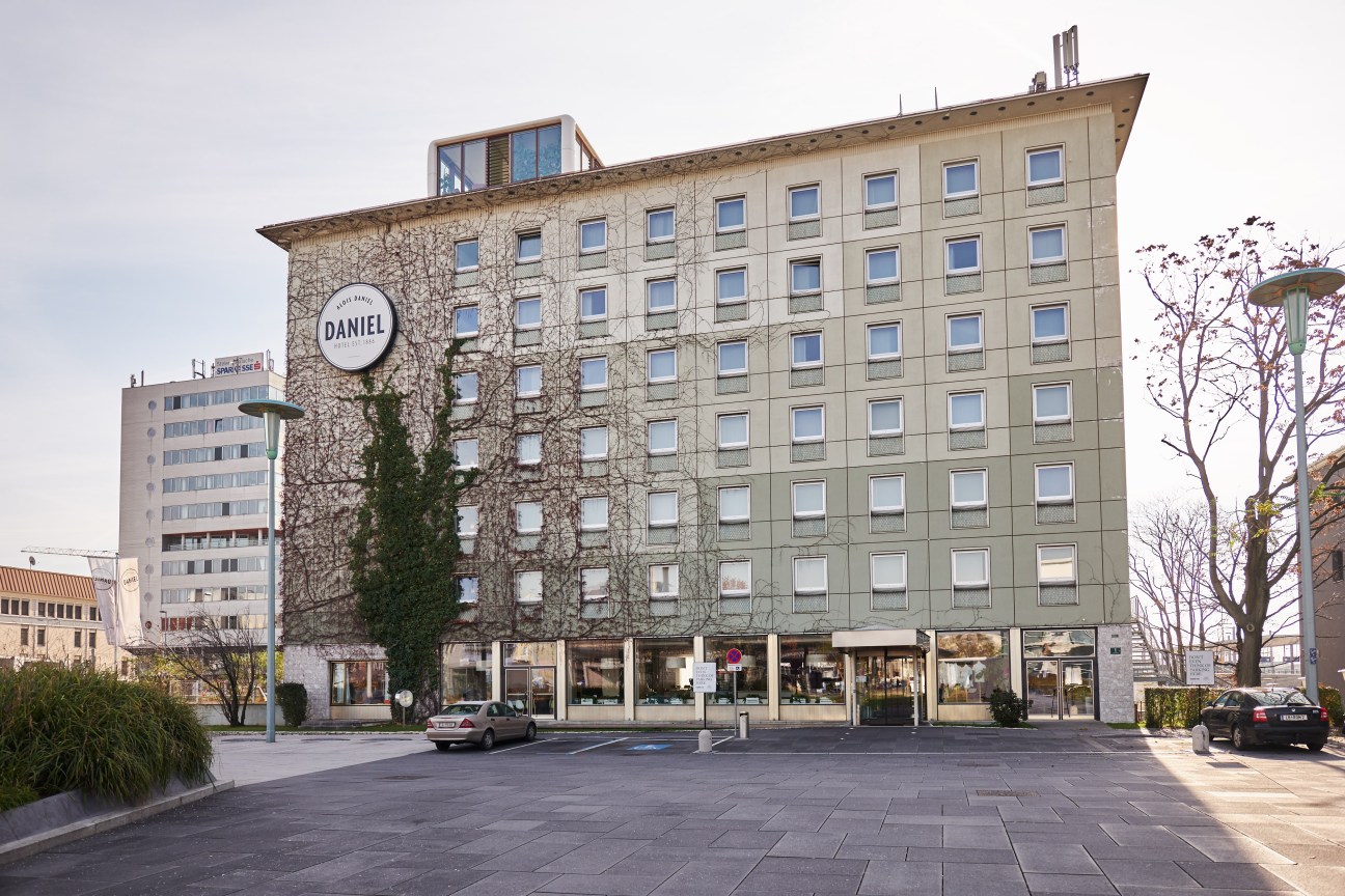 Hotel Daniel, a multi-story building with ivy-covered facade and circular signage, located in Graz's city center.