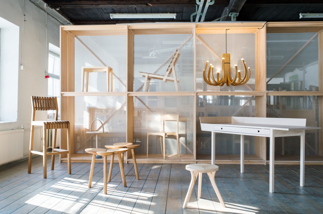 Showroom display of wooden furniture by Nikari including chairs, tables, and a pendant light.