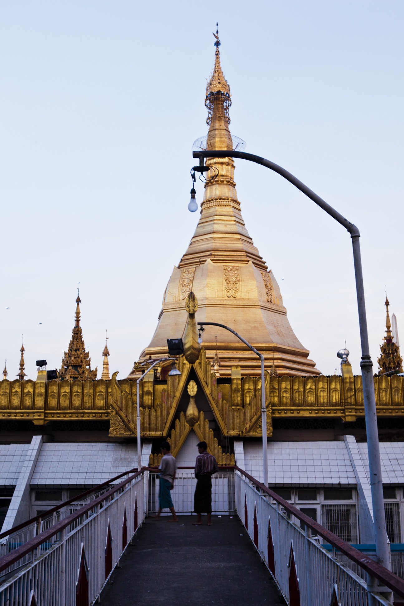 Golden Sule Pagoda with ornate spire surrounded by smaller golden stupas and modern street lamp.