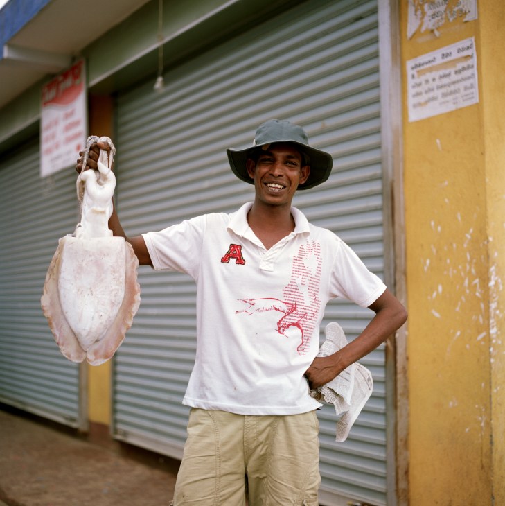 Local deep sea diver Rasike holding a large squid at Hambantota market.