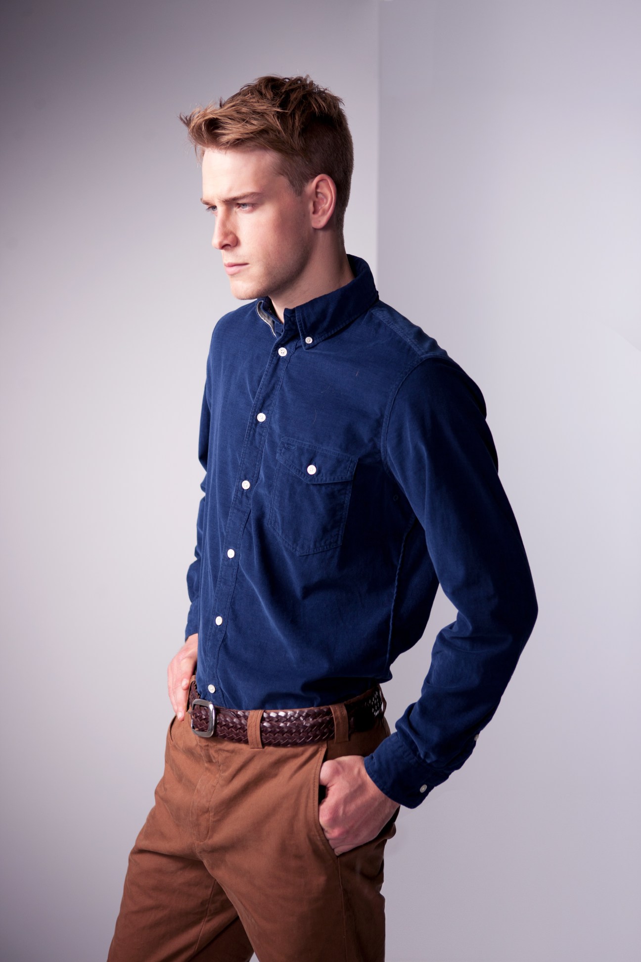 Man wearing navy button-down shirt and tan chinos with braided belt, modelling Steven Alan and Dockers collaboration.