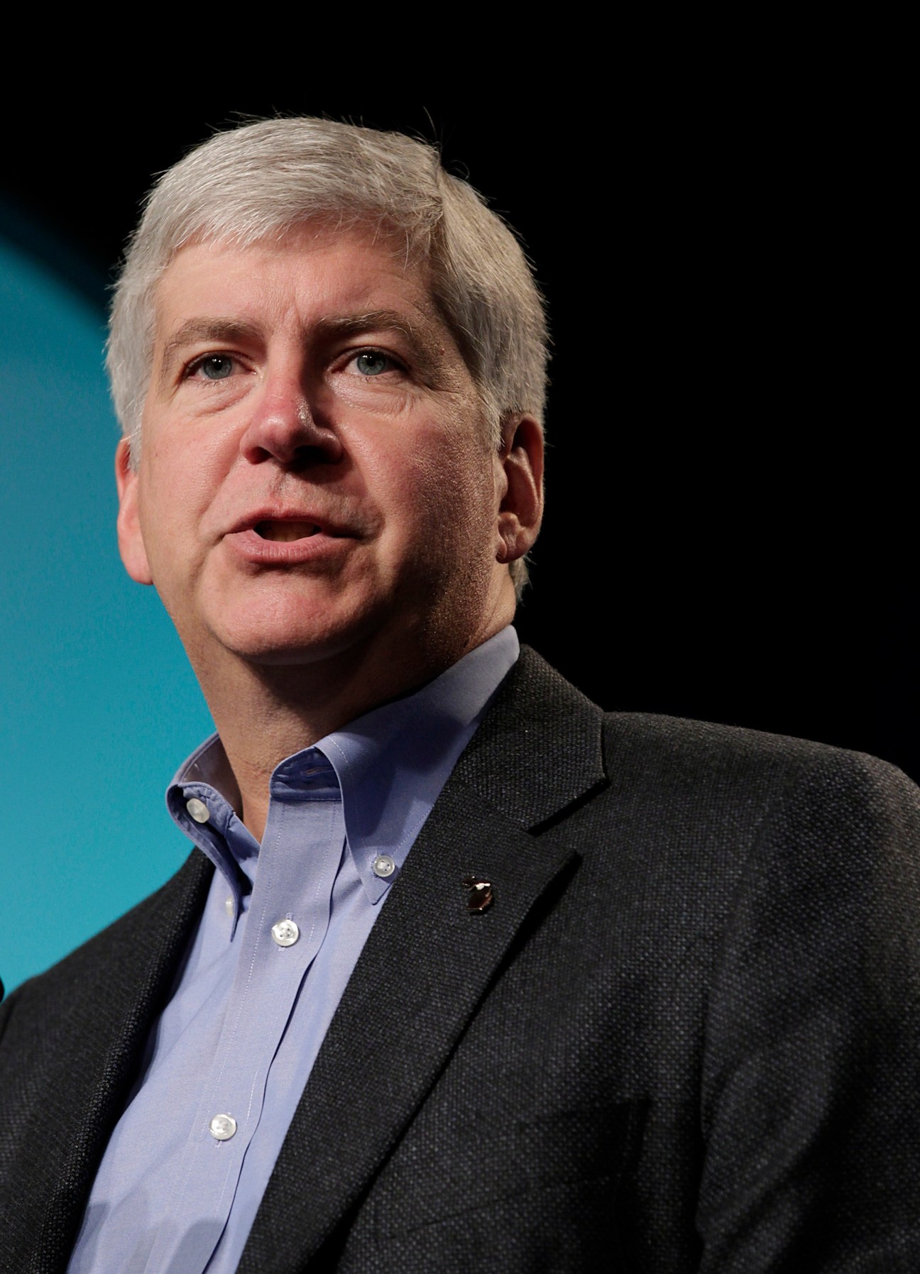 Rick Snyder, Michigan governor, in professional headshot against blue and black background.
